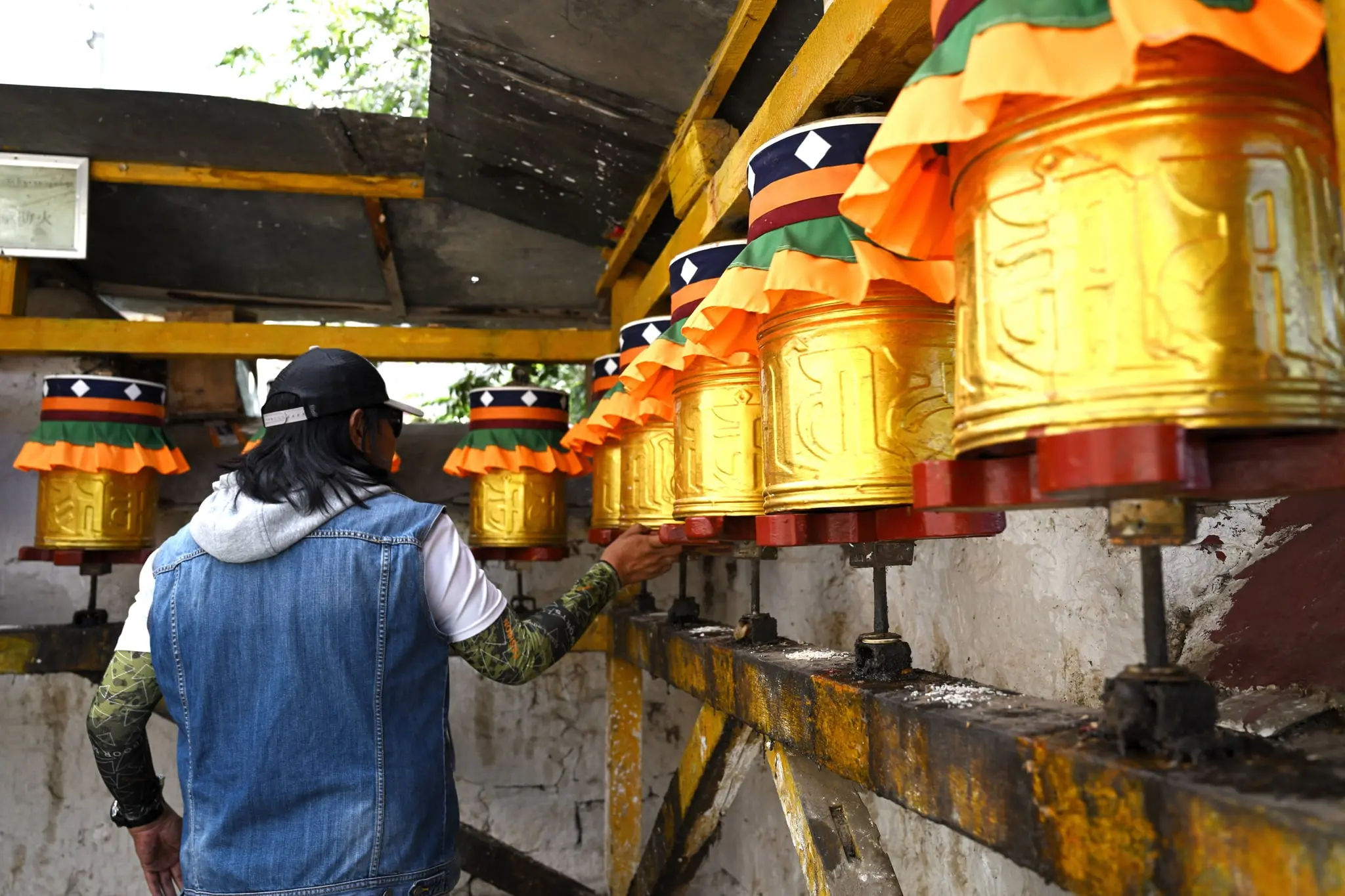 Tenzing Lhasa, our trusted guide rotating the prayer wheels in Drepung Monastery