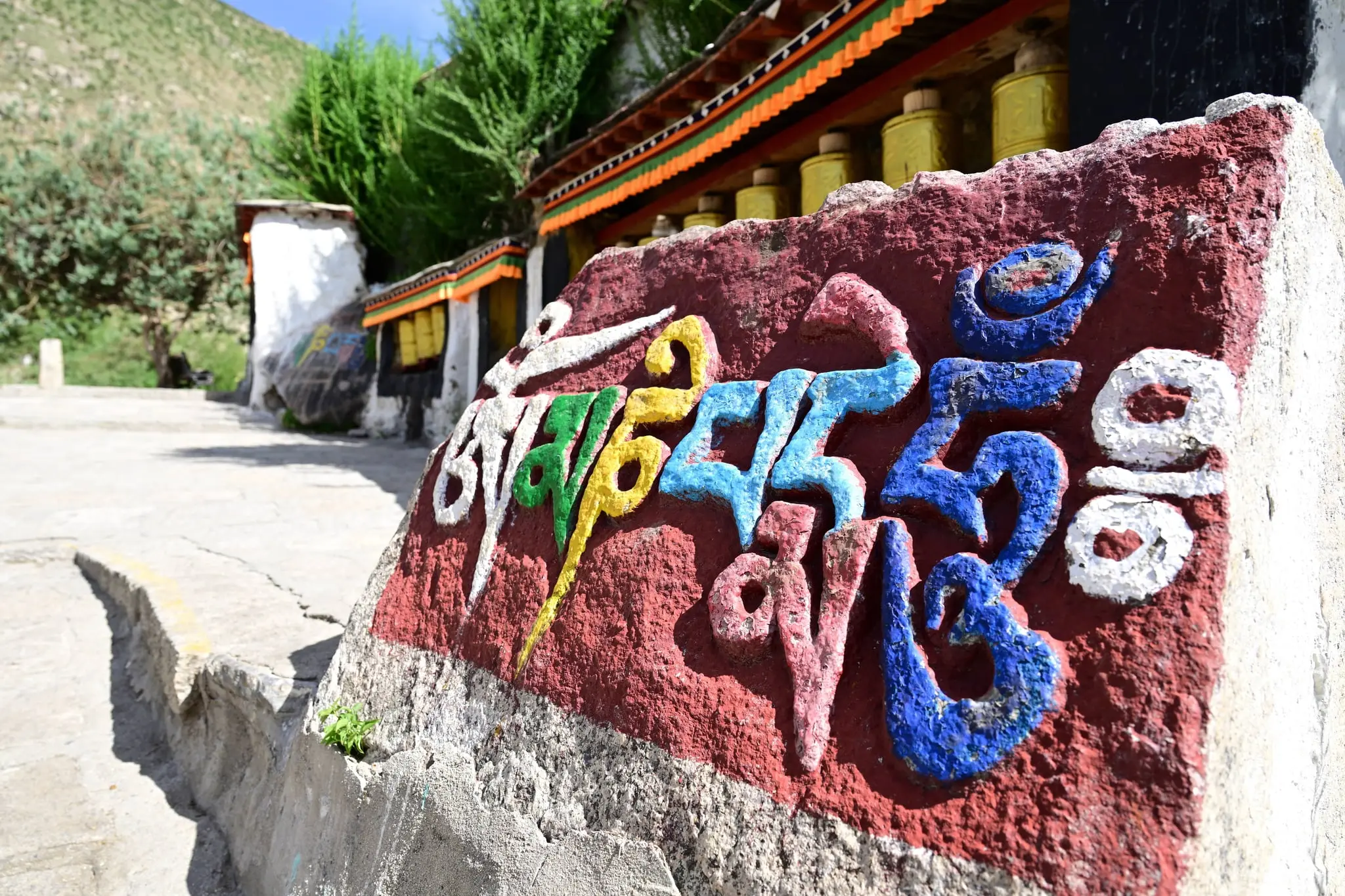 The engraving of mantra and the prayer wheels at Drepung Monastery